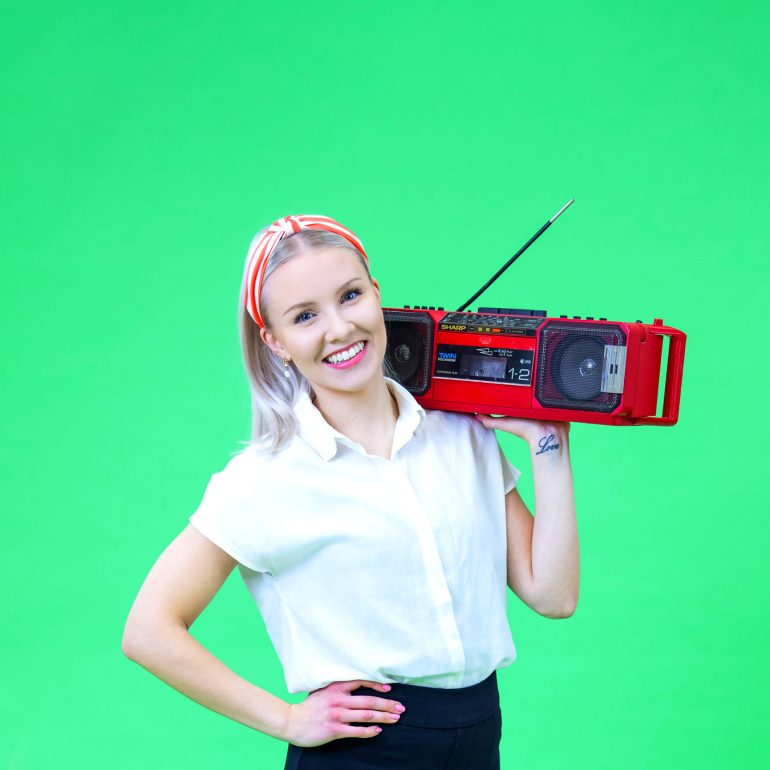 Lakeuden osuuspankki header-kuva, jossa vaalea nainen ja käsissään punainen radio.